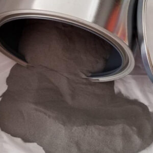 Close up of powdered steel pouring out of a tin on a white blanket.
